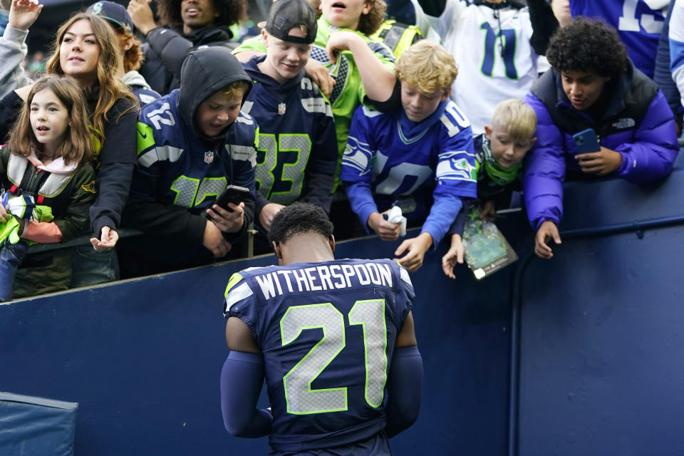 Seattle Seahawks cornerback Devon Witherspoon signs autographs for fans after an NFL football game against the Arizona Cardinals Sunday, Oct. 22, 2023, in Seattle. The Seahawks won 20-10. (AP Photo/Lindsey Wasson)