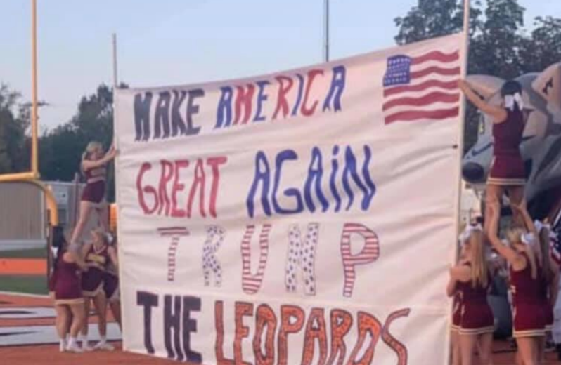 Arkansas school in the US with cheerleaders holding sign with Trump slogan.