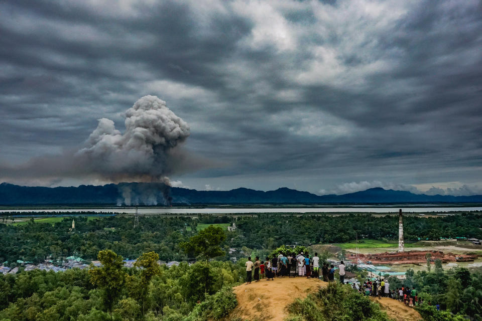 <p>Watch houses burn: A group of Rohingya at the Leda makeshift settlement in Cox’s Bazar, Bangladesh, watch as houses burn just across the border in Myanmar, Sept. 9, 2017.<br>After militants of the Arakan Rohingya Salvation Army (ARSA) launched an assault on a Myanmar government police post in August, Rohingya villages were targeted and houses burned, causing an exodus of refugees to Bangladesh. The Myanmar government blamed ARSA for the village attacks. According to the refugees themselves and Human Rights Watch, which analyzed satellite imagery, Myanmar security forces set the fires. By the end of November more than 350 villages had been partially or completely destroyed. (Photo: Md Masfiqur Akhtar Sohan/NurPhoto Agency) </p>