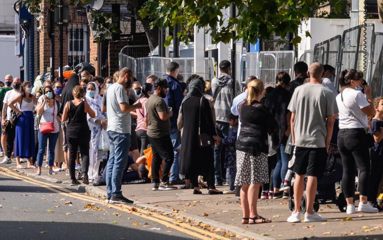 Queues stretch along the pavement at a walk-in Covid-19 testing centre in London  - Getty Images Europe