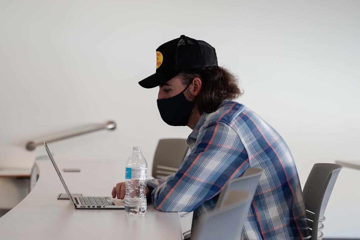 A University of Kansas student works from his laptop during an entrepreneurship class. KU cut the ACT test from admissions requirements, and some legislators are pushing back.