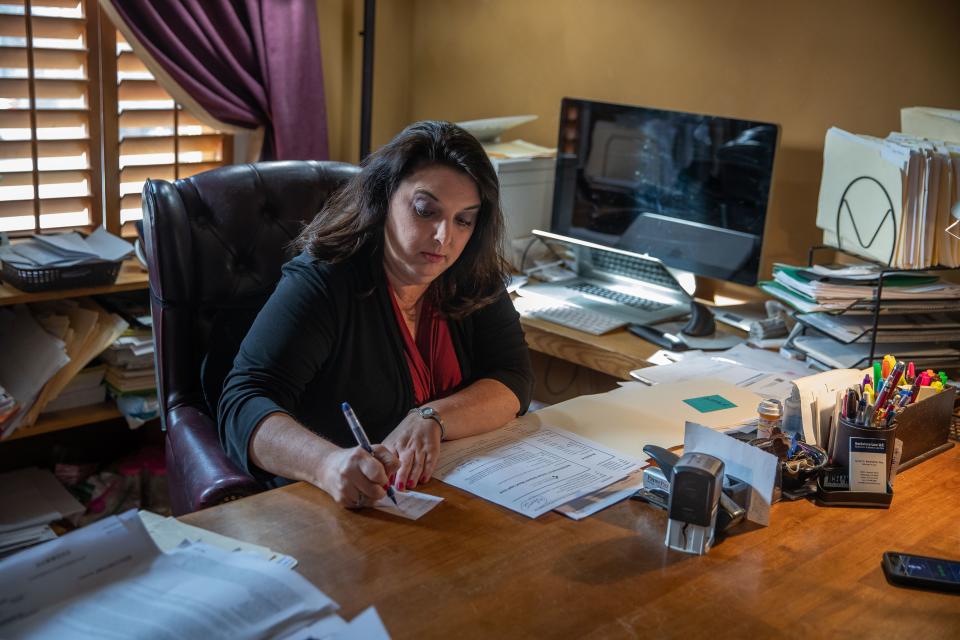 Indianapolis attorney Jynell Berkshire sifts through a pile of notes on her desk inside her home office on Tuesday, March 12, 2019. The notes are from calls she's had with investors concerned about their dealings with Morris Invest and Oceanpointe regarding properties they purchased in Indianapolis.