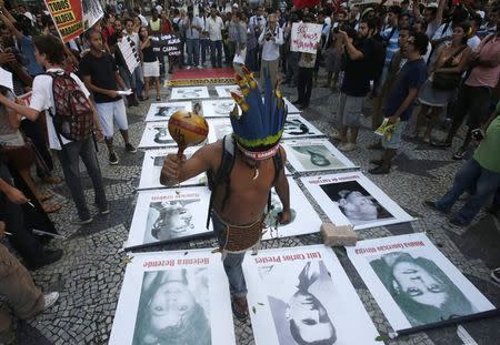 A native Indian walks over pictures of people who disappeared during a military dictatorship at a protest against the 49th anniversary of the Brazil's 1964 military coup in Rio de Janeiro in this April 1, 2013 file photo. REUTERS/Ricardo Moraes