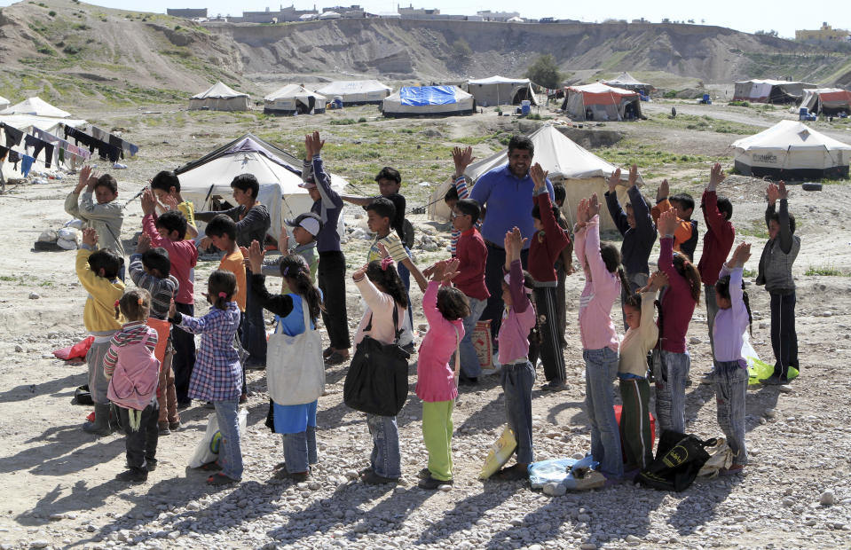 Syria- Isolated Refugees -- In this Thursday, Feb. 20, 2014 photo, Jordanian volunteer teacher Mohammed Marahleh holds a physical education class for Syrian refugees in Northern Shuneh area of Jordan Valley, north of Amman, Jordan. About 2.3 million Syrians have fled the three-year old Syrian conflict, seeking shelter in Jordan, Lebanon, Turkey and Iraq, according to UNHCR figures. At least half, or 1.1 million, are children. (AP Photo/Raad Adayleh)