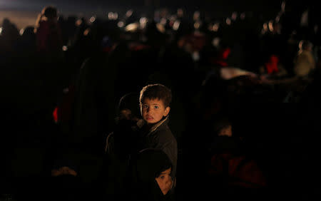 A boy looks at the camera, near the village of Baghouz, Deir Al Zor province, Syria February 25, 2019. Picture taken February 25, 2019. REUTERS/Rodi Said