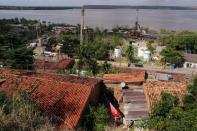 A man hangs laundry near a mining equipment used by the petrochemical company Braskem in Maceio