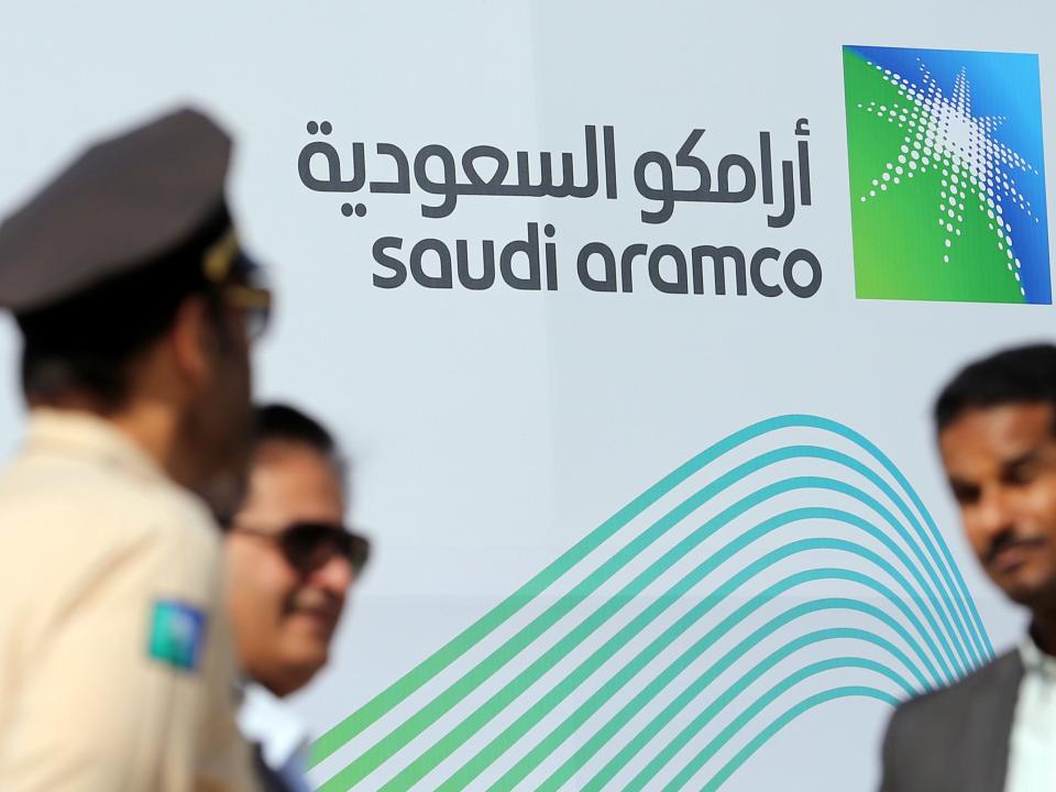 Logo of Aramco behind security personnel.