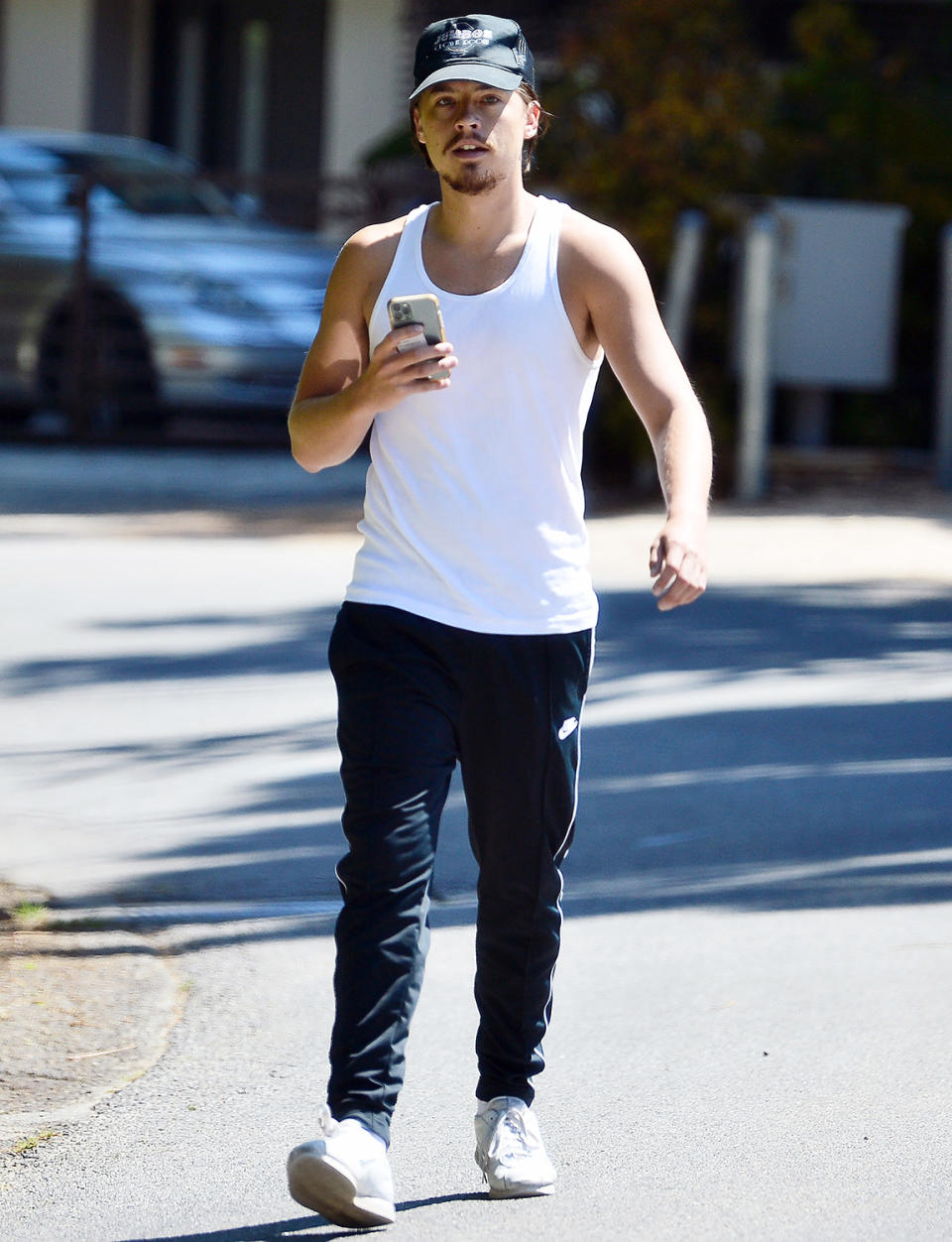 <p>Cole Sprouse checks his phone as he starts his hike around the Hollywood Hills on Tuesday.</p>