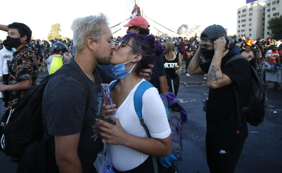 Una pareja se besa en la Plaza Italia después de un plebiscito para decidir si el país debe reemplazar su constitución de hace 40 años, redactada durante la última dictadura militar, en Santiago, Chile, el domingo 25 de octubre de 2020. (AP Foto/Luis Hidalgo)