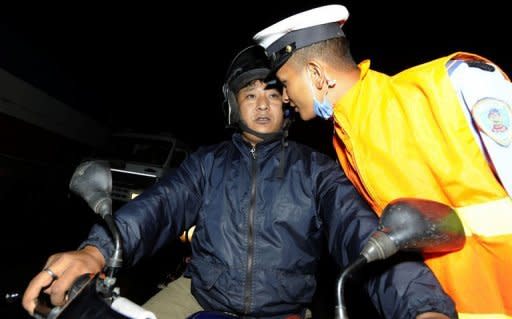 A Nepalese traffic policeman smells the breath of a motorcyclist to determine the level of his alcohol consumption at a roadblock in Kathmandu. With breathalysers scarce and blood tests unavailable, the method for catching lawbreakers in Kathmandu is primitive as police officers simply stop drivers and engage them in conversation