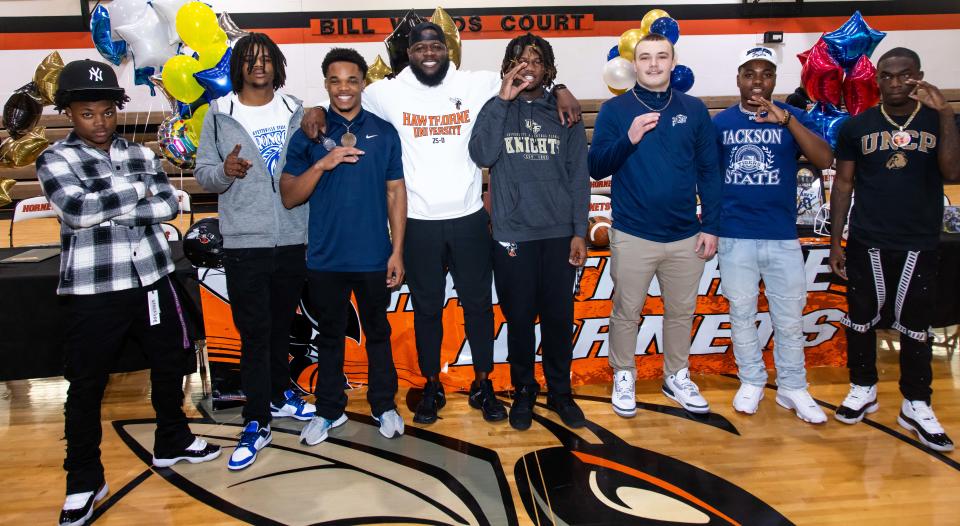 Hawthorne High School celebrated National Signing Day with seven of their football players signing letters of intent with colleges throughout the country. Head Football Coach Cornelius Ingram, fourth from left, introduced all seven and spoke about their contributions to the team before they all signed. Que King, left, signed with University of North Carolina at Pembroke, Demetri Perry, second from left, signed with Fayetteville State University, Jamarion Davenport, third from left, signed with Andrew College, Caleb Rollerson, fifth from left, signed with University of Central Florida, Andrew Zock, third from right, signed with United States Naval Academy, Earick Williams, second from right, signed with Jackson State and Jordin Fluellen, right, signed with University of North Carolina at Pembroke. [Doug Engle/Ocala Star Banner]2024