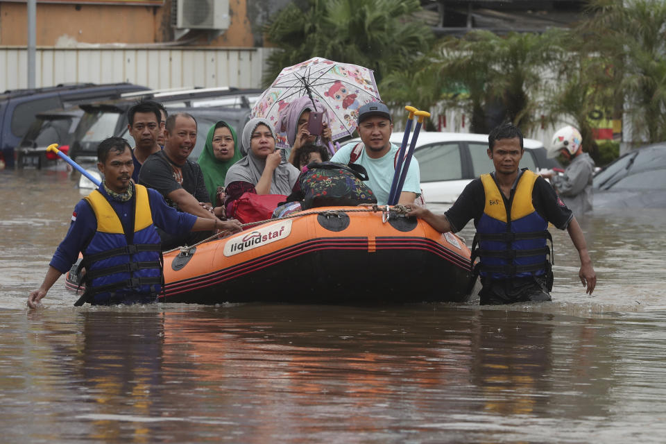 Indonesia rescue team evacuate residents from their flooded house at Jatibening on the outskirt of Jakarta, Indonesia, Wednesday, Jan. 1, 2020. Severe flooding hit Indonesia's capital just after residents celebrating New Year's Eve, forcing a closure of an airport and thousands of inhabitants to flee their flooded homes.(AP Photo/Achmad Ibrahim)