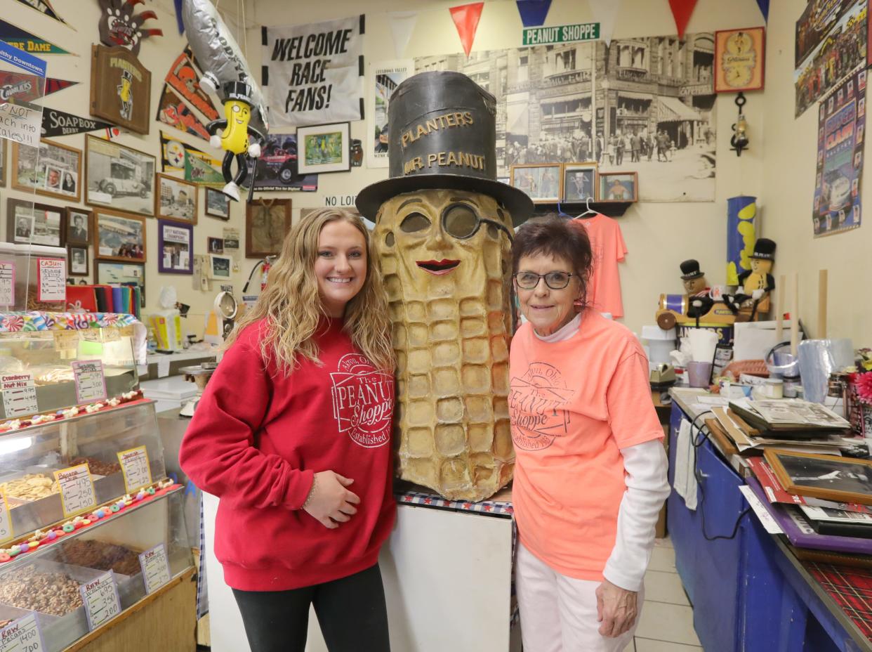 Marge Klein, owner of the Peanut Shoppe in downtown Akron, stands Wednesday with her granddaughter Molly Klein next to a 1930s costume of Mr. Peanut. The South Main Street store is 90 years old.