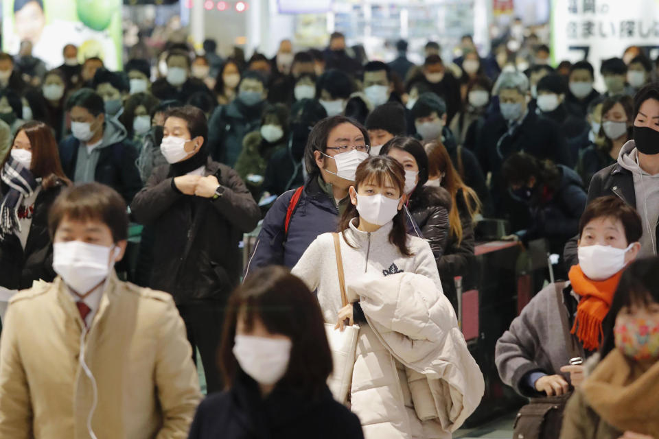 Commuters wear face masks at a station in Fukuoka, southern Japan Thursday, Jan. 14, 2021. Japan expanded a coronavirus state of emergency to seven more prefectures, affecting more than half the population amid a surge in infections across the country. (Naoyuki Shin/Kyodo News via AP)