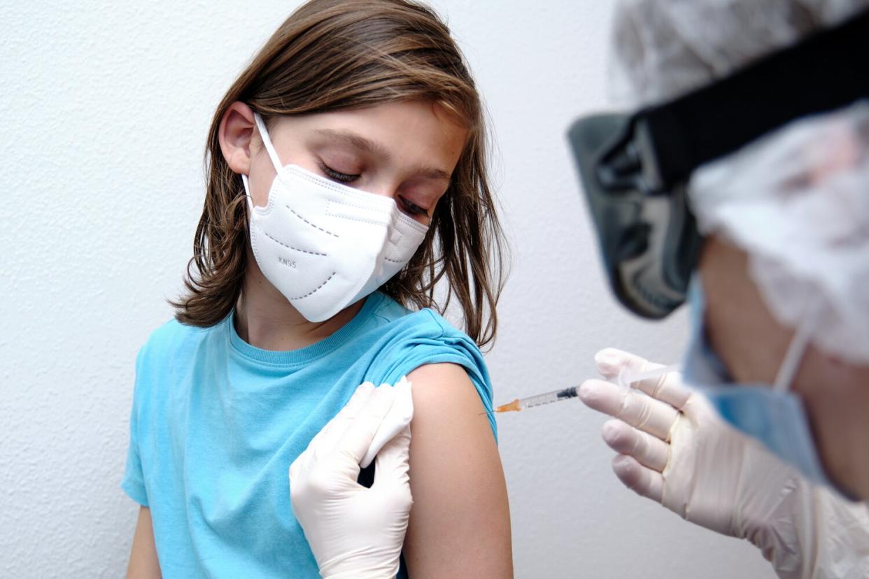 Female doctor giving covid-19 vaccine to a boy