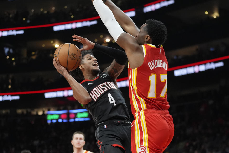 Houston Rockets guard Jalen Green (4) goes in of a shot as Atlanta Hawks forward Onyeka Okongwu (17) defends during the first half of an NBA basketball game Saturday, Feb. 10, 2024, in Atlanta. (AP Photo/John Bazemore)