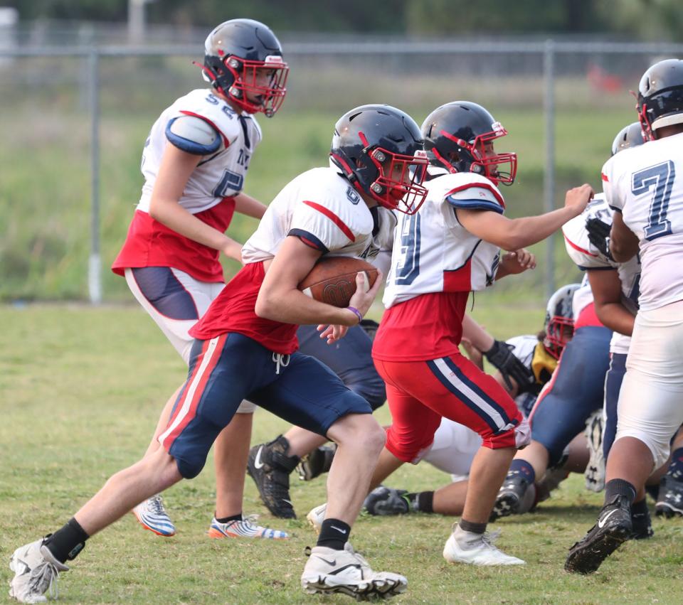 Taylor's Josiah Smith takes a handoff during spring practices.