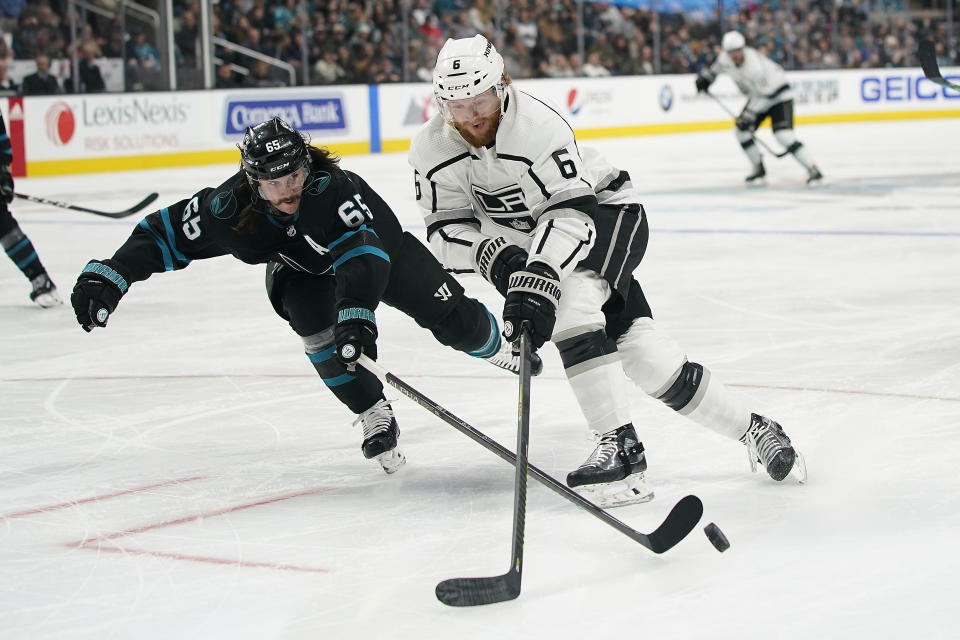 San Jose Sharks defenseman Erik Karlsson (65) pokes the puck away from Los Angeles Kings defenseman Joakim Ryan (6) during the second period of an NHL hockey game in San Jose, Calif., Friday, Dec. 27, 2019. (AP Photo/Tony Avelar)