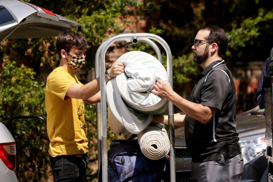 Evan Olinger of Sellersburg, Indiana, loads a cart with his dad, Scott Olinger, as Evan moves into his Purdue University dorm in August 2020.