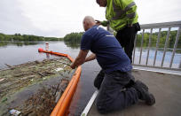 <p>Activist Rocky Morrison, left, of the “Clean River Project” examines a boom filled with waste collected from a recovery boat on the Merrimack River in Chelmsford, Mass. Morrison leads a cleanup effort along the Merrimack River, which winds through the old milling city of Lowell, and has recovered hundreds of needles in abandoned homeless camps that dot the banks, as well as in piles of debris that collect in floating booms he recently started setting. (Photo: Charles Krupa/AP) </p>