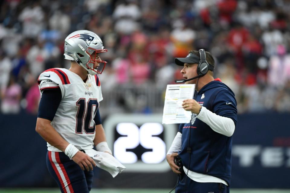 New England Patriots quarterback Mac Jones (10) talks with offensive coordinator Josh McDaniels during a timeout against the Texans in the second half, Sunday, Oct. 10, 2021, in Houston.