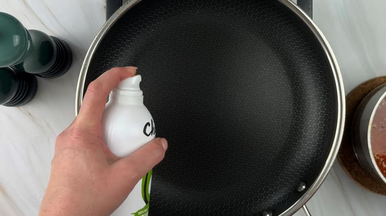 hand spraying frying pan