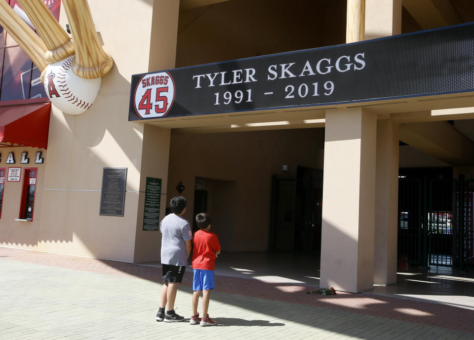 Benji and Alex Villa give their condolences for pitcher Tyler Skaggs at Angel Stadium in Anaheim, Calif., Monday, July 1, 2019. Skaggs died at the age of 27, stunning Major League Baseball and leading to the postponement of the team's game against the Texas Rangers on Monday. (AP Photo/Alex Gallardo)