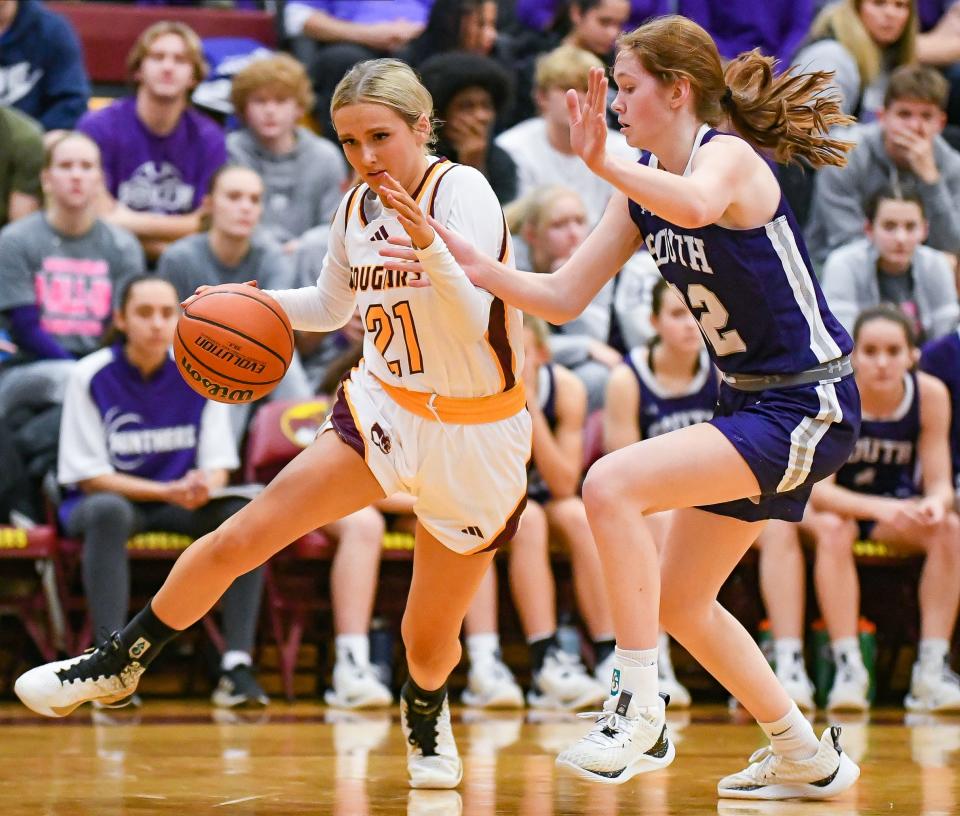 Bloomington North’s Ava Reitmeyer (21) drives to the basket against Bloomington South’s Julia Lashley (32) during their game at North on Thursday, Dec. 14, 2023.