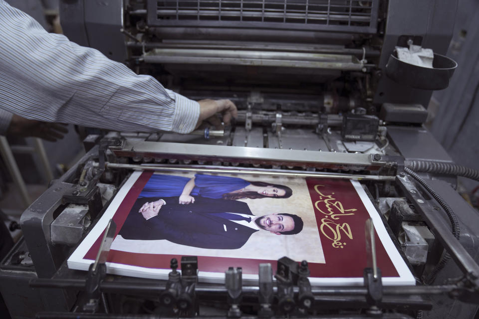 A Jordanian specialist follows the process of printing posters with pictures of Crown Prince Hussein and his fiancee, Saudi architect Rajwa Alseif and reads "we celebrate Hussein," at a print house in Amman, Jordan, Wednesday, May 31, 2023. Crown Prince Hussein and Saudi architect Rajwa Alseif are to be married on Thursday at a palace wedding in Jordan, a Western-allied monarchy that has been a bastion of stability for decades as Middle East turmoil has lapped at its borders.(AP Photo/Nasser Nasser)