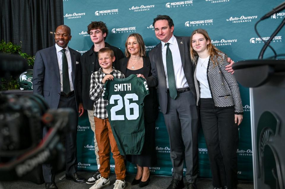 Michigan State football coach Jonathan Smith poses with his family and athletic director Alan haller, at left, during an introductory press conference on Tuesday, Nov. 28, 2023, at the Breslin Center in East Lansing.