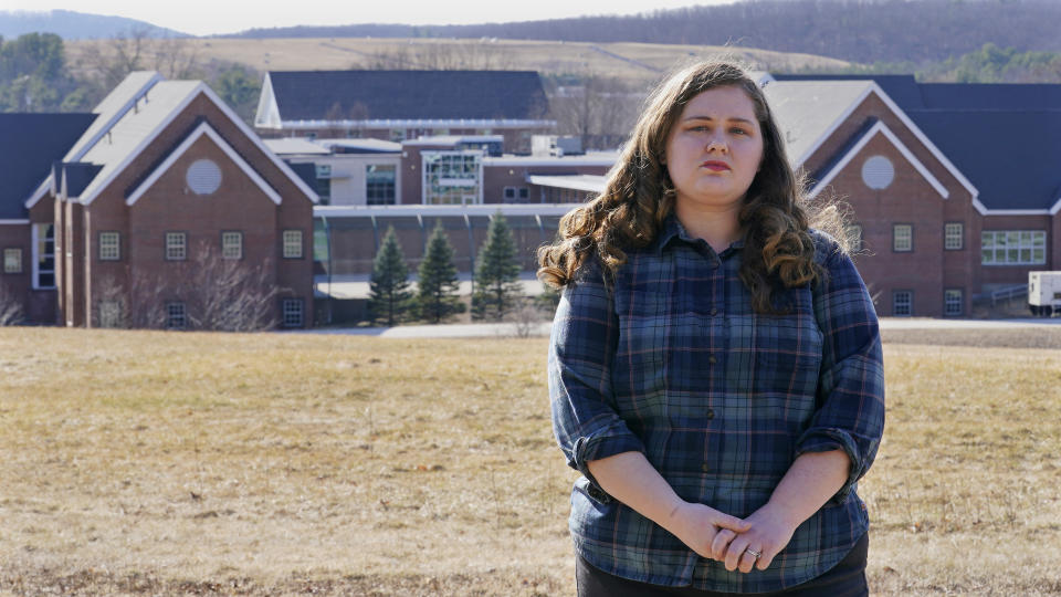 Mary Goddard poses outside the Sununu Youth Development Center, Tuesday, March 23, 2021, in Manchester, N.H. Goddard, a former intern at New Hampshire’s youth detention center says a supervisor suggested she destroy her notes and lie about a teen’s sexual assault allegation. And though she reported the boy’s claim to state investigators and police, it wasn’t included in an annual report that state officials submitted to the federal government.(AP Photo/Charles Krupa)