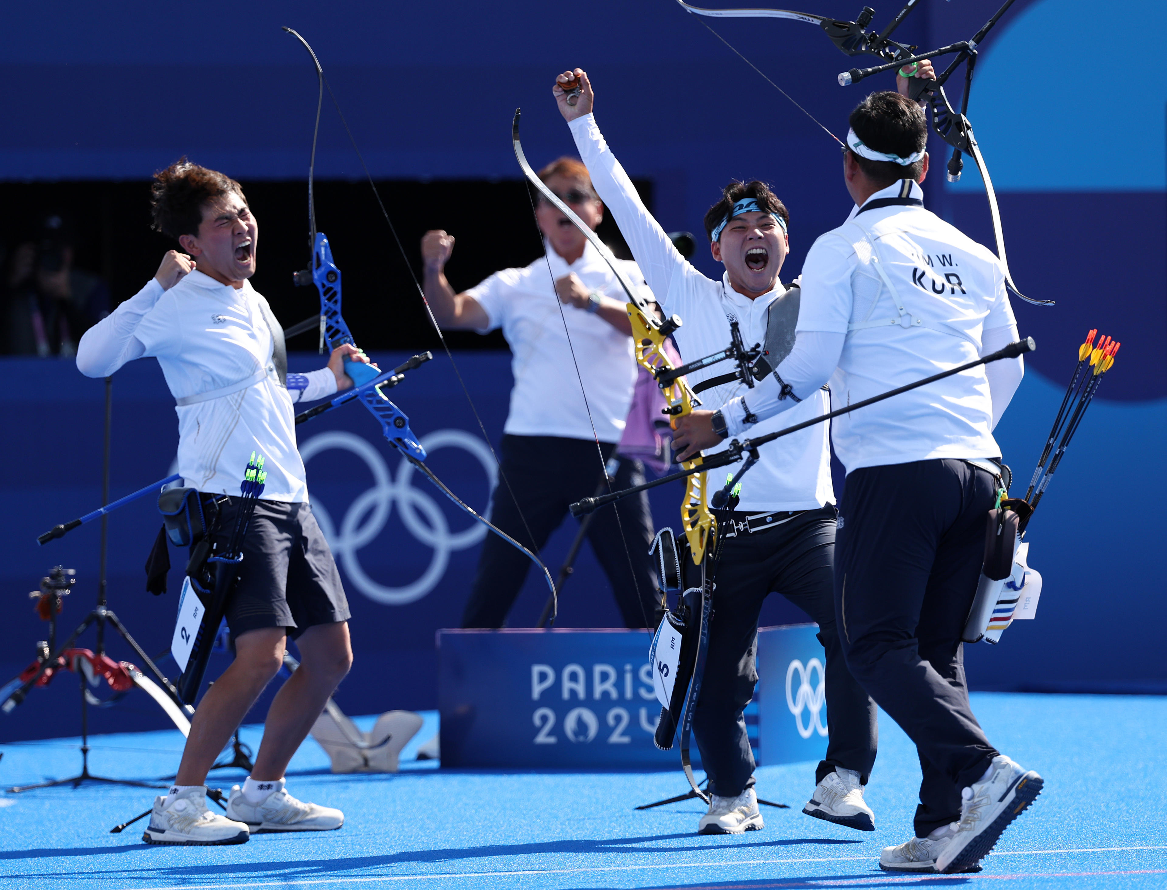 PARIS, FRANCE - JULY 29: Je Deok Kim, Woojin Kim and Wooseok Lee of Team Republic of Korea celebrate winning the gold medals after competing in the Archery Men's Team Gold Medal match against Team France on day three of the Olympic Games Paris 2024 at Esplanade Des Invalides on July 29, 2024 in Paris, France. (Photo by Julian Finney/Getty Images)