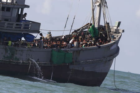 A Myanmar military officer (top) speaks on the radio from a boat packed with migrants off Leik Island in the Andaman Sea May 31, 2015. REUTERS/Soe Zeya Tun