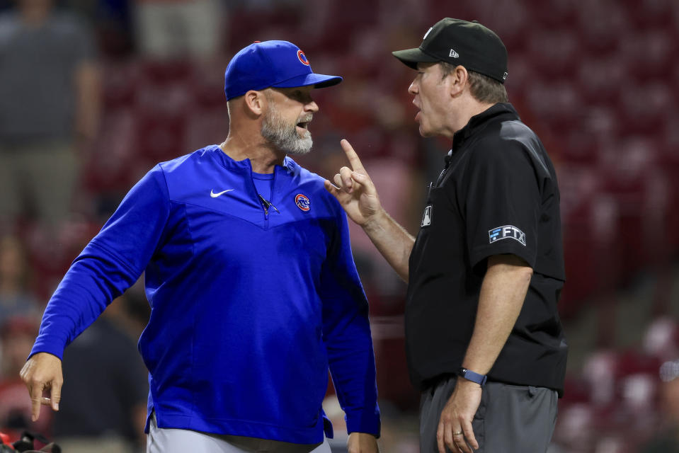 Chicago Cubs' David Ross, left, argues with umpire Chris Conroy, after being ejected by Dan Merzel during the ninth inning of the team's baseball game against the Cincinnati Reds in Cincinnati, Wednesday, May 25, 2022. The Reds won 4-3. (AP Photo/Aaron Doster)