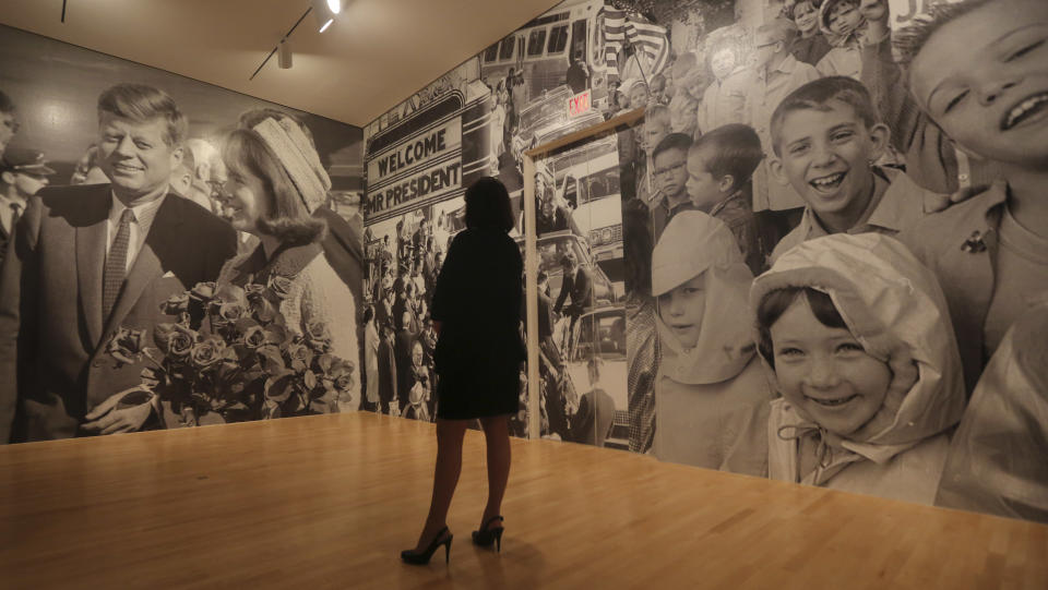 A woman looks giant photos include in the exhibit "Hotel Texas: An Art Exhibition for the President and Mrs. John F. Kennedy," during a press preview at the Dallas Museum of Art Wednesday, May 22, 2013, in Dallas. The exhibit reunites 14 of the 16 works that were placed in Suite 850 for the Kennedys' one-night stay in Fort Worth and includes photos of the suite before and after the artwork was placed there, video footage of the room being prepared for the Kennedys and historical artifacts from the visit, including a sign welcoming the Kennedys to Texas. (AP Photo/LM Otero)