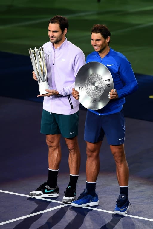 Roger Federer and second-placed Rafael Nadal of Spain hold their trophies after the men's singles final match at the Shanghai Masters tennis tournament