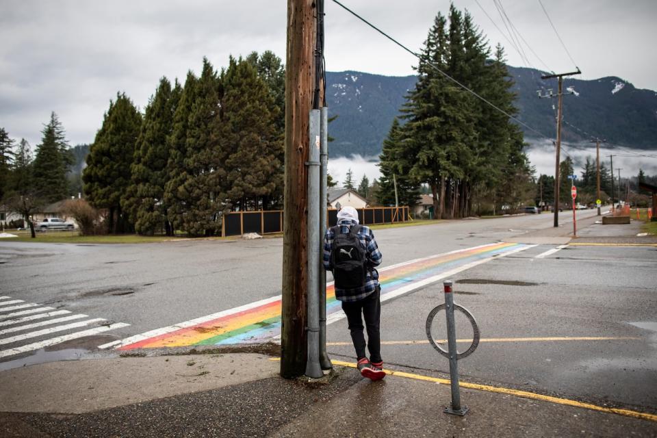 A person stands on the side of a street in Hope, B.C. on Wednesday, Jan. 31, 2024. 