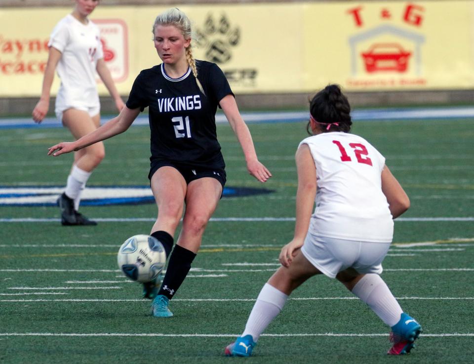 Lakeland Christian junior K.J. Straub (21) drives the ball down field as All Saints' Aaliyah Rodriguez defends on Thursday night in the Class 2A, District 7 championship match at Viking Stadium.