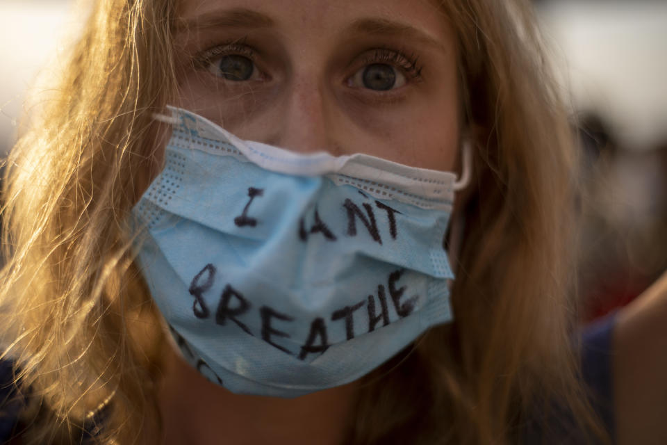 A protester wears a face mask to curb the spread of the coronavirus during a protest to decry the killing of George Floyd in front of the American embassy in Tel Aviv, Israel, Tuesday, June 2, 2020.(AP Photo/Ariel Schalit)