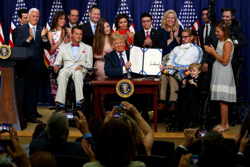 President Donald Trump holds up the "Right to Try" act after signing it in the South Court Auditorium on the White House campus, on May 30, 2018 in Washington.