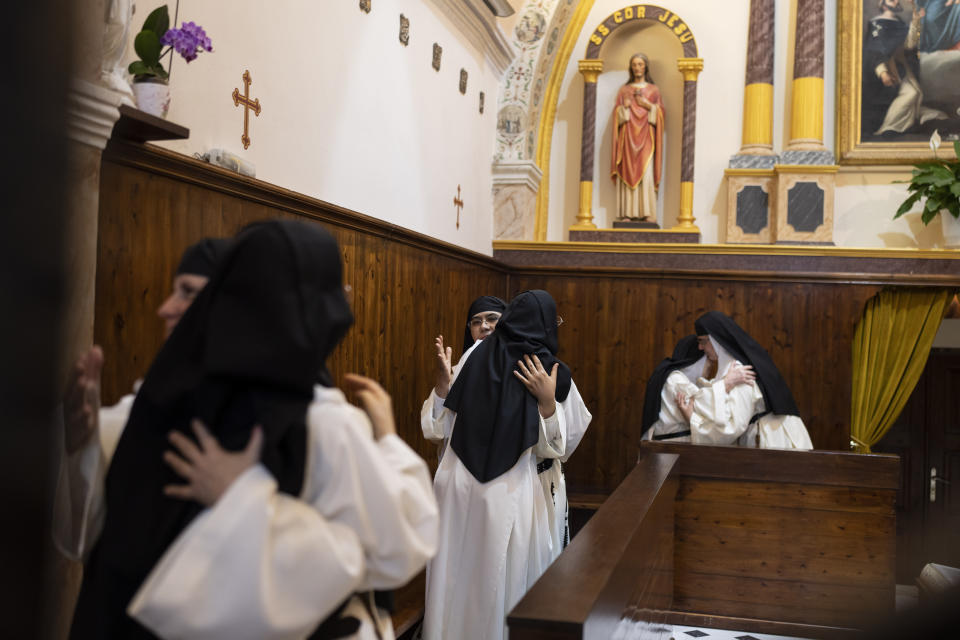 Las monjas de clausura se abrazan durante una misa en el Monasterio Católico de Santa Catalina en la isla griega de Santorini el 14 de junio de 2022. (Foto AP/Petros Giannakouris)