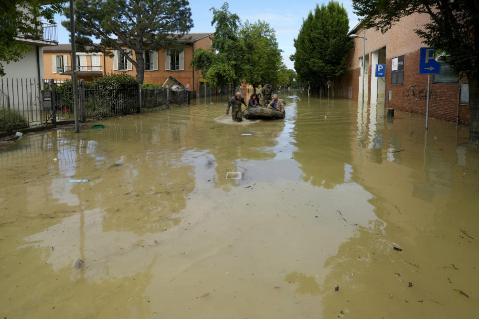 People are rescued in Faenza, Italy, Thursday, May 18, 2023. Exceptional rains Wednesday in a drought-struck region of northern Italy swelled rivers over their banks, killing at least nine people, forcing the evacuation of thousands and prompting officials to warn that Italy needs a national plan to combat climate change-induced flooding. (AP Photo/Luca Bruno)