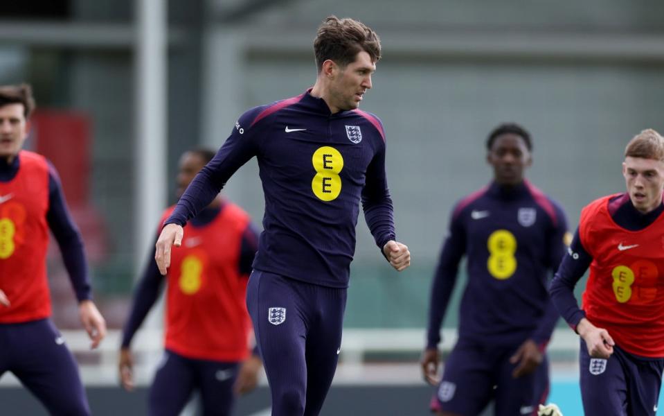 England's John Stones runs with the ball during training at St Georges Park in Burton-upon-Trent on March 22, 2024