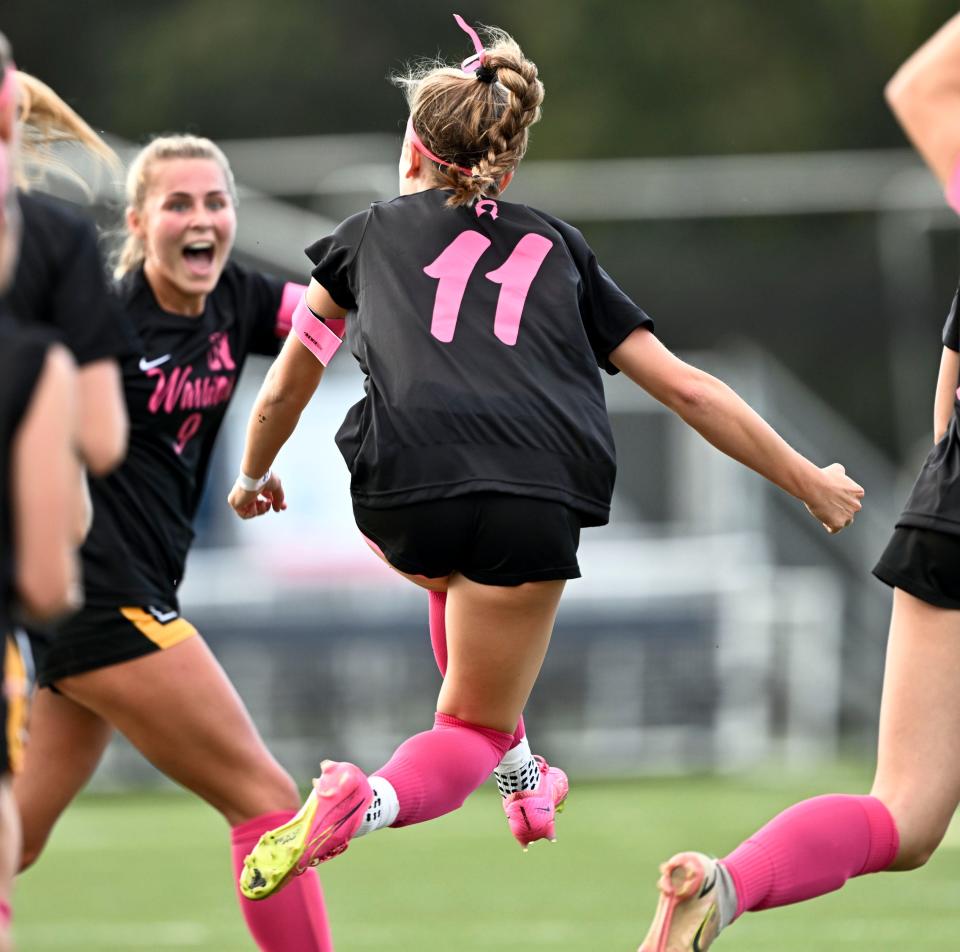Olivia Avellar (11) leaps to celebrate with her Nauset teammate Caroline Kennard after the connected for the only goal in the game with Falmouth.