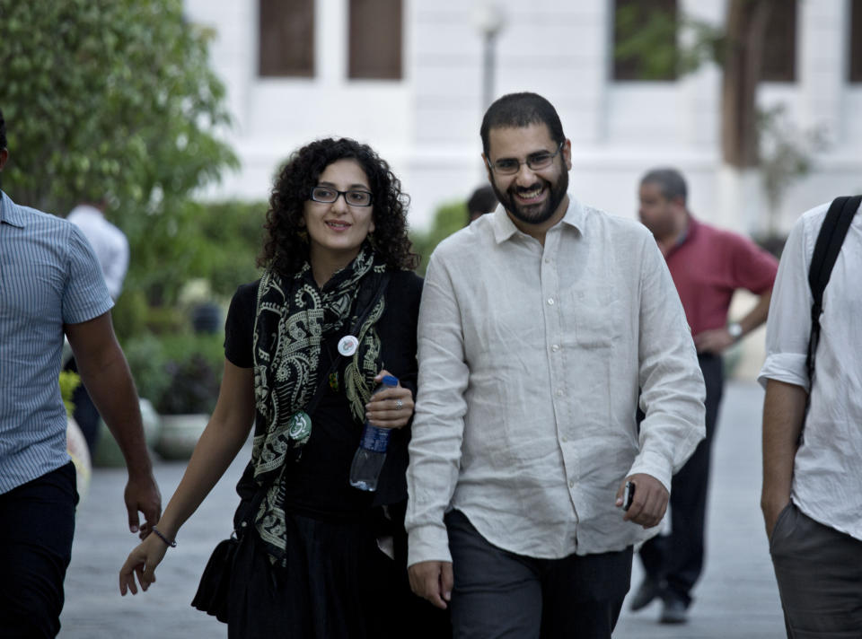 FILE - In this Sept. 22, 2014 file photo, Egypt's leading pro-democracy activist Alaa Abdel-Fattah walks with his sister Mona Seif prior to a conference held at the American University in Cairo, near Tahrir Square, Egypt. Abdel-Fattah was released from prison early Friday March 29, 2019, after serving a five-year sentence for inciting and taking part in protests, his family and lawyer said. (AP Photo/Nariman El-Mofty, File)