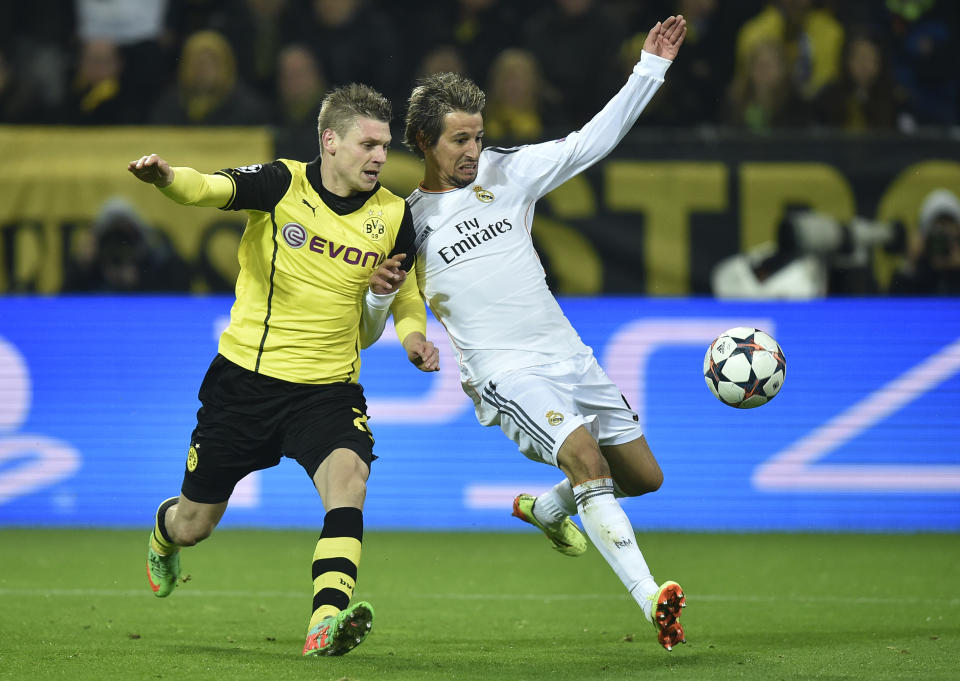 Real's Fabio Coentrao, right, fights for the ball with Dortmund's Lukasz Piszczek during the Champions League quarterfinal second leg soccer match between Borussia Dortmund and Real Madrid in the Signal Iduna stadium in Dortmund, Germany, Tuesday, April 8, 2014. (AP Photo/Martin Meissner)