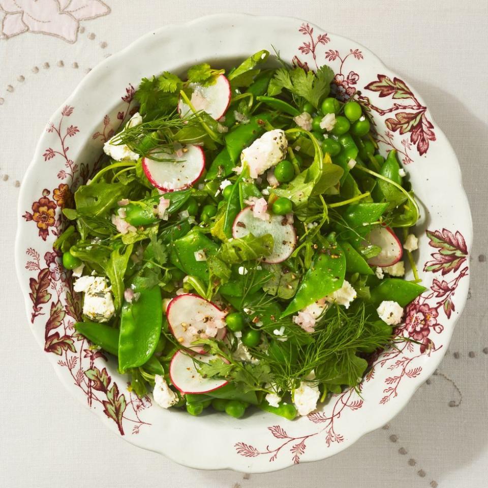 arugula three pea salad with radishes on white and red plate