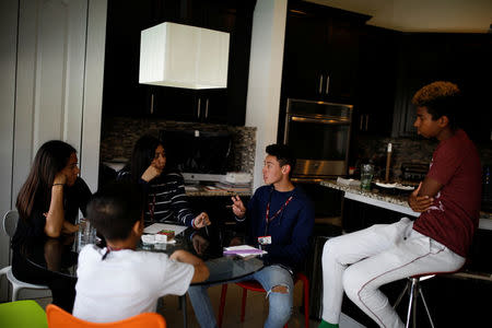 Carlos Rodriguez (2nd R), student and shooting survivor from Marjory Stoneman Douglas High School, talks with his schoolmates and co-founders of Stories Untold, a movement created to encourage victims of gun violence to share their stories, during a meeting at his house in Parkland, Florida, U.S., April 10, 2018. REUTERS/Carlos Garcia Rawlins