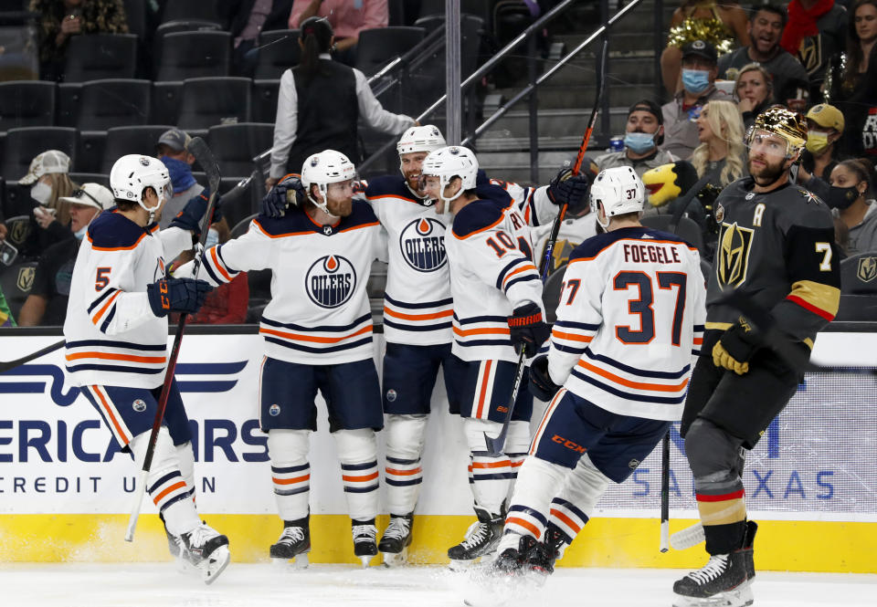 Edmonton Oilers right wing Zack Kassian, center, celebrates with teammates after scoring during the third period of the team's NHL hockey game against the Vegas Golden Knights on Friday, Oct. 22, 2021, in Las Vegas. Golden Knights defenseman Alex Pietrangelo skates by at right. (AP Photo/Steve Marcus)