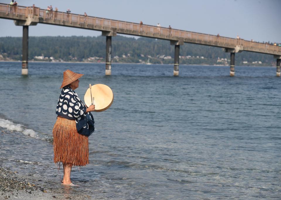 Suquamish elder Peg Deam drums and sings as the tribe welcomes the traditional Polynesian Voyaging Canoe Hōkūleʻa to the shore in Suquamish on Aug. 24.